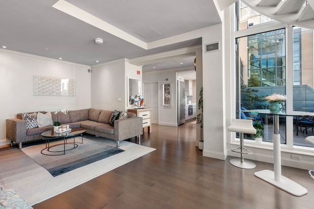 living room with crown molding, dark hardwood / wood-style flooring, and plenty of natural light