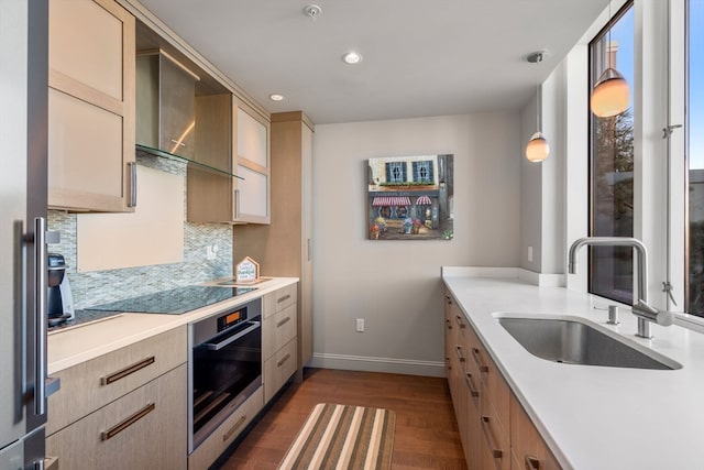 kitchen featuring pendant lighting, oven, sink, tasteful backsplash, and dark hardwood / wood-style flooring