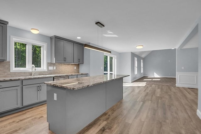 kitchen with pendant lighting, gray cabinets, tasteful backsplash, and a kitchen island