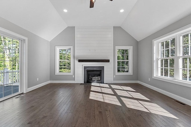 unfurnished living room featuring vaulted ceiling, ceiling fan, a fireplace, and dark hardwood / wood-style flooring