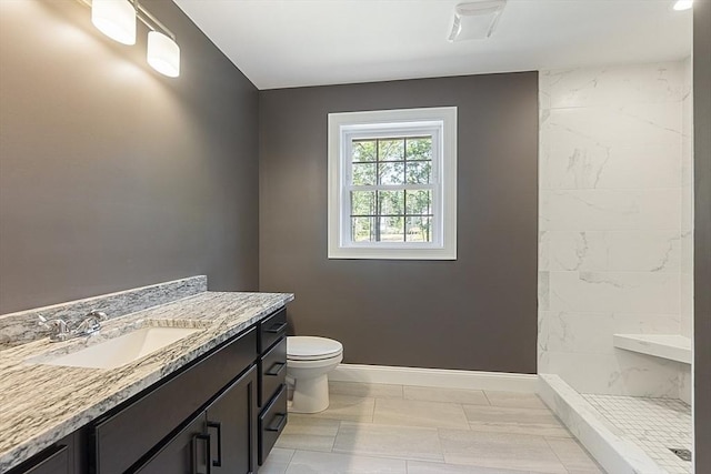 bathroom featuring vanity, toilet, and tiled shower