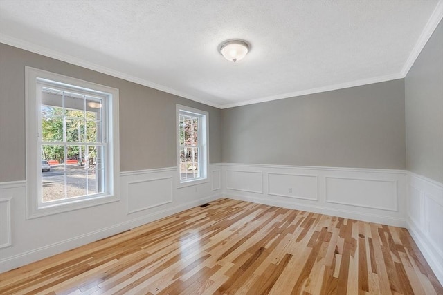 unfurnished room featuring ornamental molding and light wood-type flooring