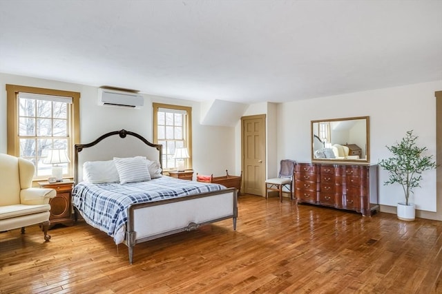 bedroom featuring an AC wall unit and light wood-style flooring