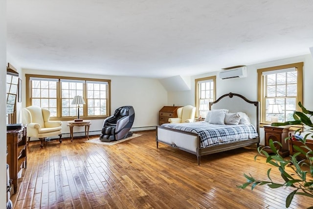 bedroom featuring a wall mounted air conditioner, multiple windows, and hardwood / wood-style flooring