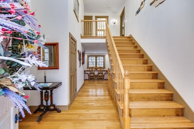 stairway featuring a high ceiling and wood finished floors