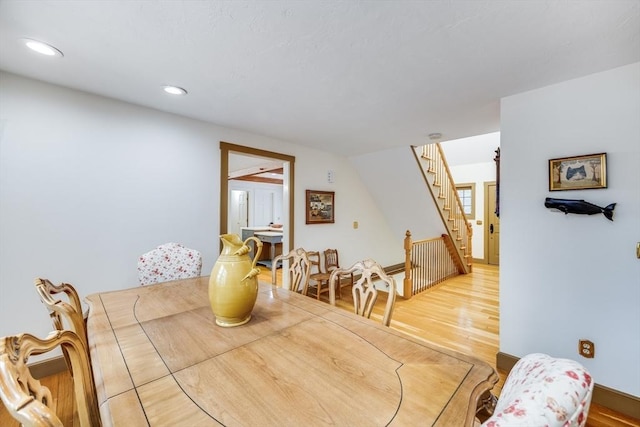 dining space featuring light wood-style floors, recessed lighting, and stairs