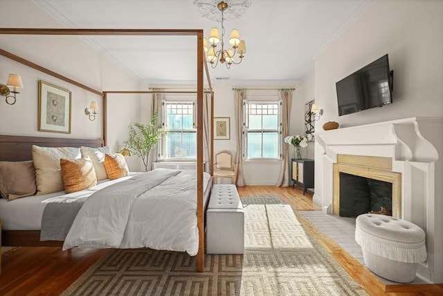 bedroom with hardwood / wood-style flooring, ornamental molding, and an inviting chandelier