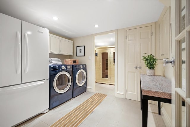 washroom featuring cabinets, light tile patterned floors, and independent washer and dryer