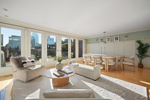 living room with light wood-type flooring and ornamental molding