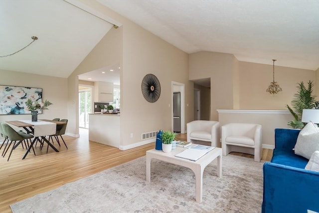 34 Brooks Rd, Wayland, MA 01778 - living area featuring vaulted ceiling, light wood-style flooring, baseboards, and a chandelier