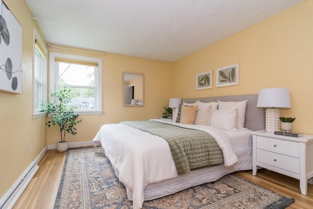 34 Brooks Rd, Wayland, MA 01778 - bedroom with baseboard heating, light wood-type flooring, and baseboards