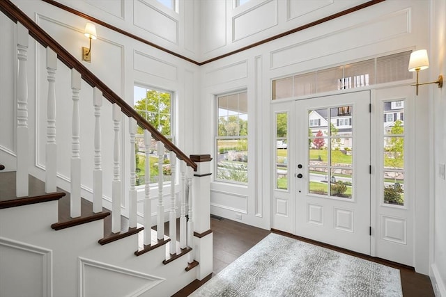 entrance foyer featuring stairway, visible vents, and a decorative wall