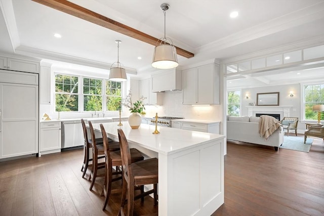 kitchen featuring dark wood finished floors, a fireplace, beamed ceiling, light countertops, and dishwasher