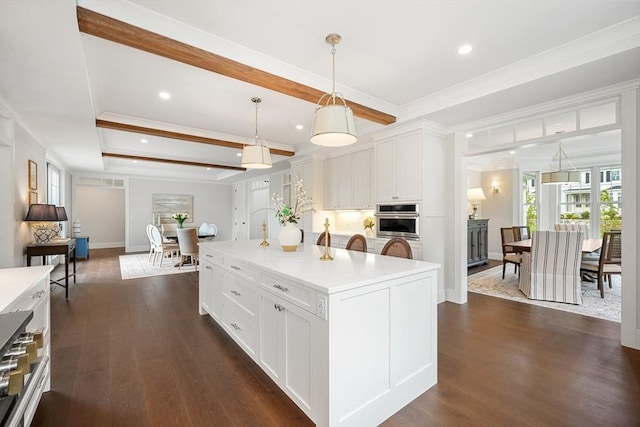 kitchen featuring dark wood-style floors, decorative light fixtures, light countertops, crown molding, and white cabinetry