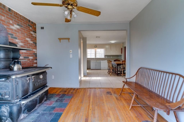 interior space featuring visible vents, light wood-style flooring, and a wood stove