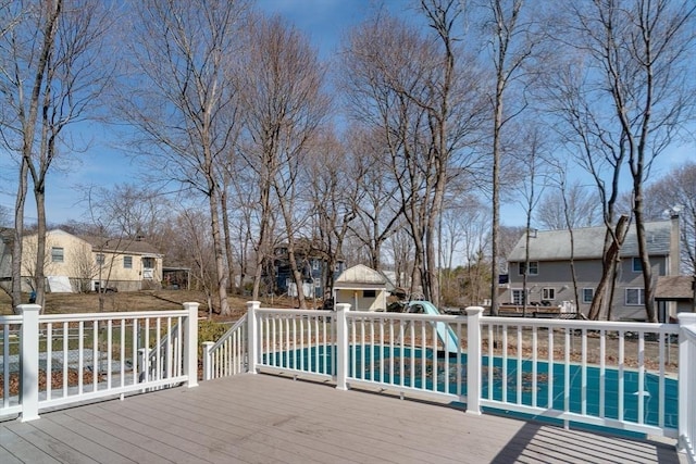 wooden terrace featuring an outdoor structure, a fenced in pool, and a residential view