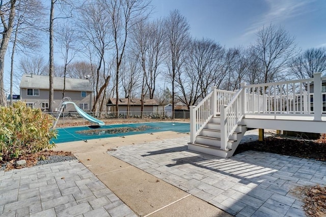 view of swimming pool with a fenced in pool, a wooden deck, a patio, and fence