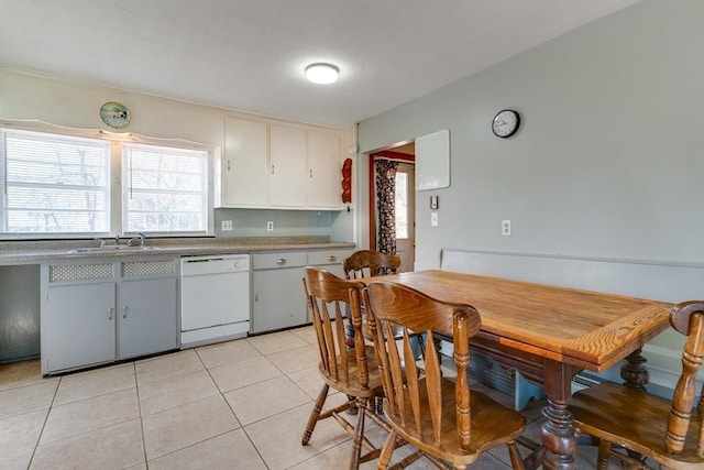 kitchen with light tile patterned flooring, dishwasher, and a sink