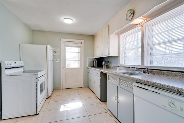 kitchen with light tile patterned flooring, white appliances, light countertops, and a sink