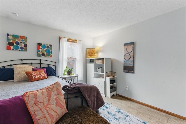 carpeted bedroom featuring baseboards and a textured ceiling
