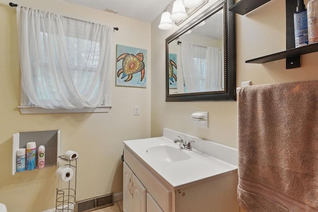 bathroom featuring visible vents, baseboards, and vanity
