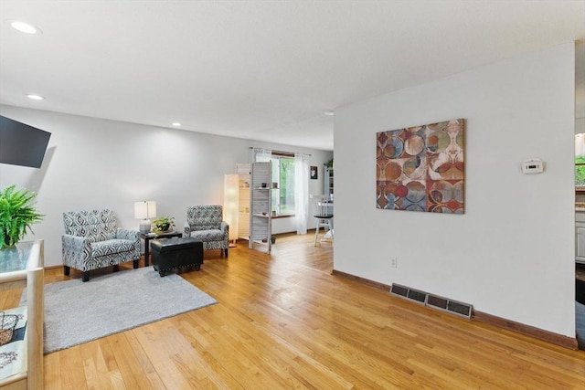 living area featuring baseboards, recessed lighting, light wood-style flooring, and visible vents