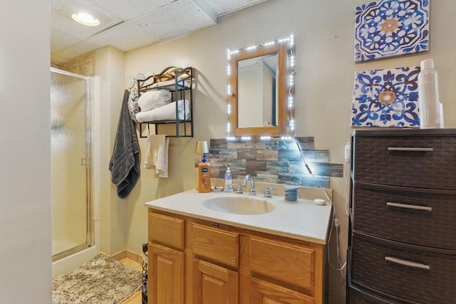 full bath featuring a shower stall, tasteful backsplash, and vanity