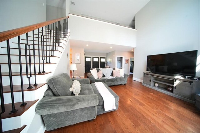 living room with a high ceiling and wood-type flooring