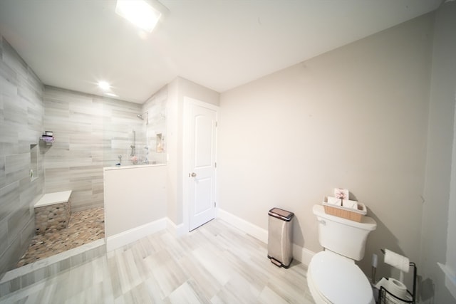 bathroom with tiled shower and toilet