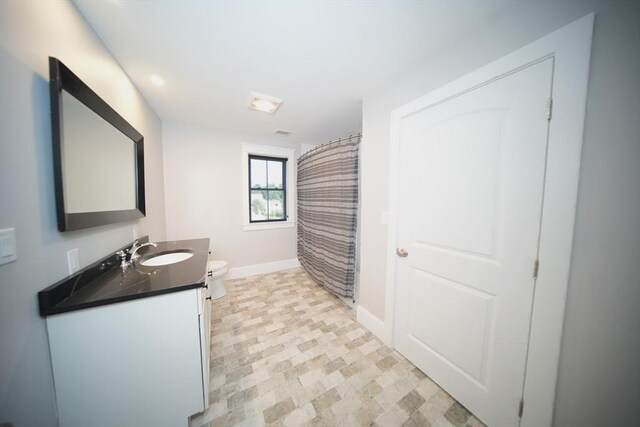 bathroom with vanity, toilet, and walk in shower