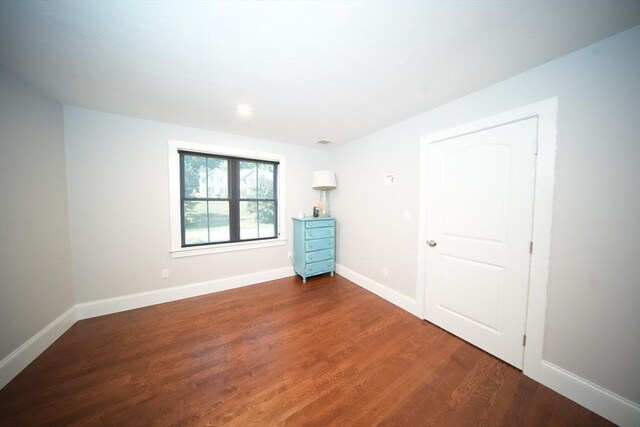 unfurnished bedroom with dark hardwood / wood-style flooring