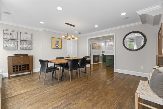 dining room with recessed lighting, wood finished floors, a fireplace, and ornamental molding