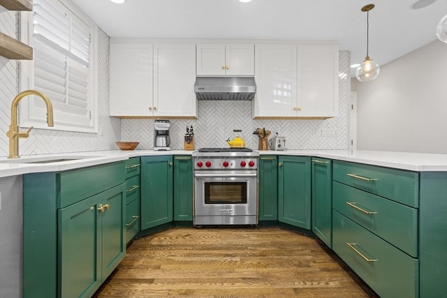 kitchen featuring under cabinet range hood, a sink, white cabinetry, premium stove, and light countertops