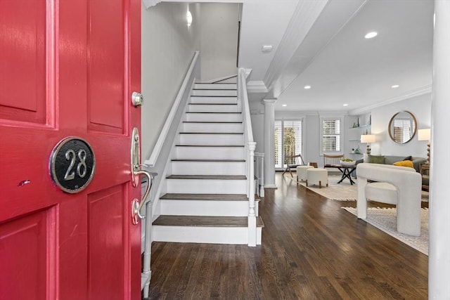 foyer with recessed lighting, wood finished floors, ornamental molding, and stairs