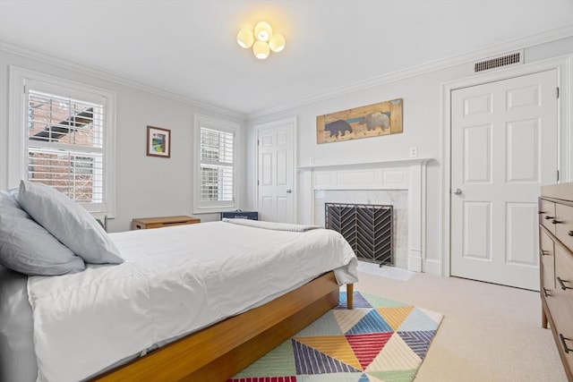 carpeted bedroom featuring a premium fireplace, visible vents, and ornamental molding