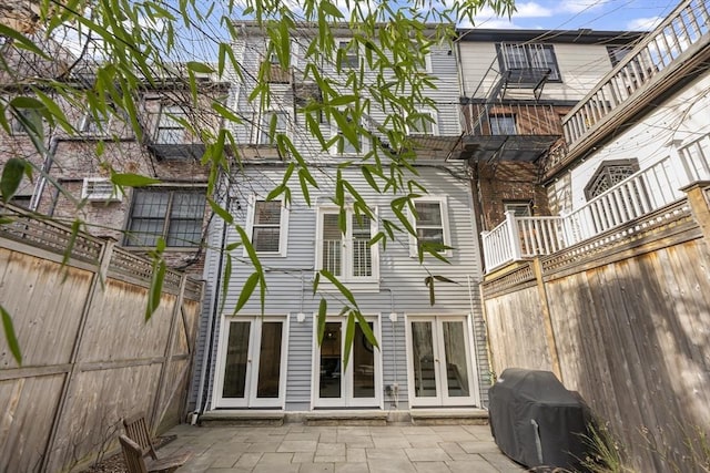 back of property with french doors, a fenced backyard, and a patio area