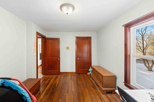 interior space featuring baseboards and dark wood-style floors