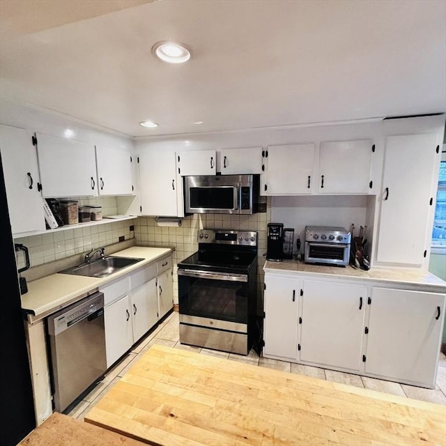 368 W St, Randolph, MA 02368 - kitchen with stainless steel appliances, a sink, white cabinets, light countertops, and recessed lighting