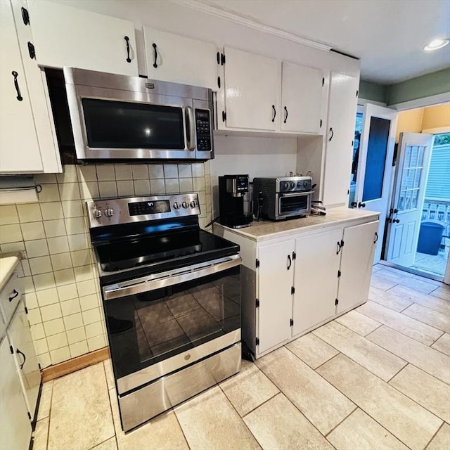 368 W St, Randolph, MA 02368 - kitchen with stainless steel appliances, white cabinets, light countertops, light tile patterned flooring, and recessed lighting