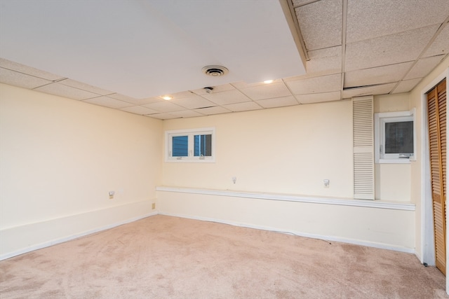 empty room with carpet and a drop ceiling