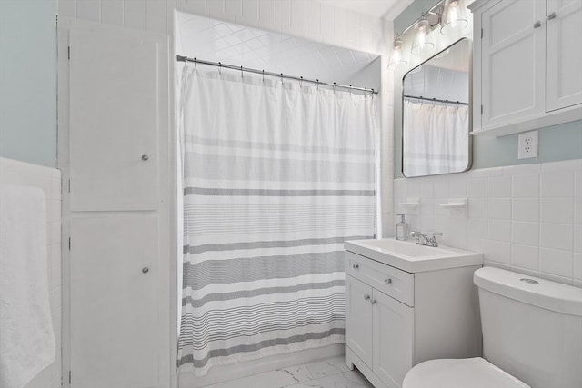 bathroom featuring vanity, toilet, marble finish floor, tile walls, and curtained shower
