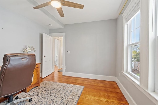 home office featuring baseboards, a ceiling fan, and light wood finished floors