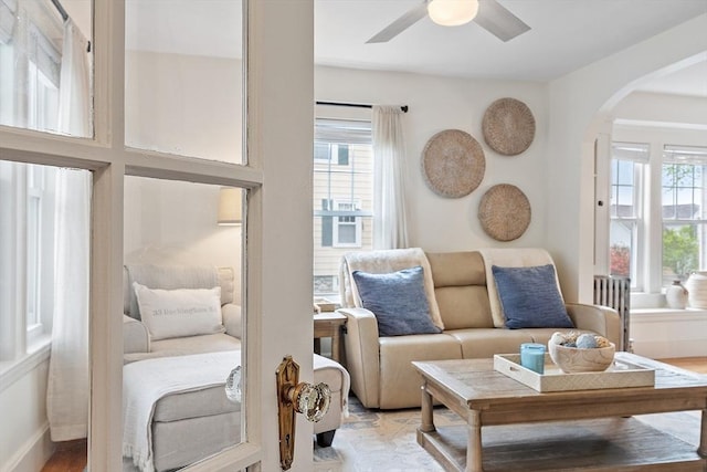 sitting room featuring arched walkways and ceiling fan
