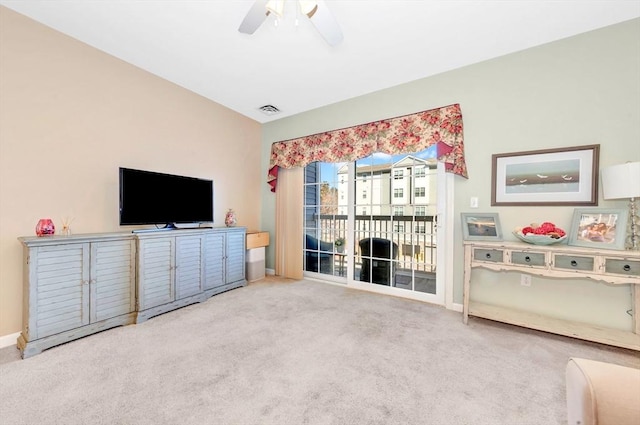 carpeted living area with visible vents, baseboards, and a ceiling fan