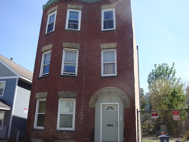 townhome / multi-family property featuring brick siding and fence