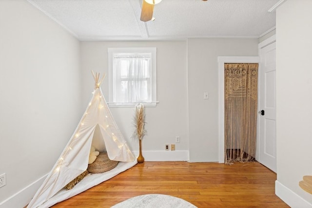 4 Rendall Pl, Melrose, MA 02176 - recreation room featuring hardwood / wood-style flooring, ornamental molding, a textured ceiling, and a ceiling fan