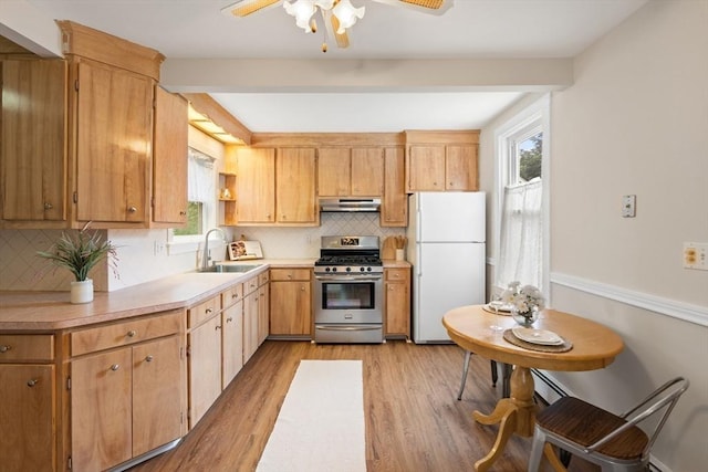 4 Rendall Pl, Melrose, MA 02176 - kitchen featuring stainless steel gas range oven, freestanding refrigerator, under cabinet range hood, a sink, and light wood-style floors