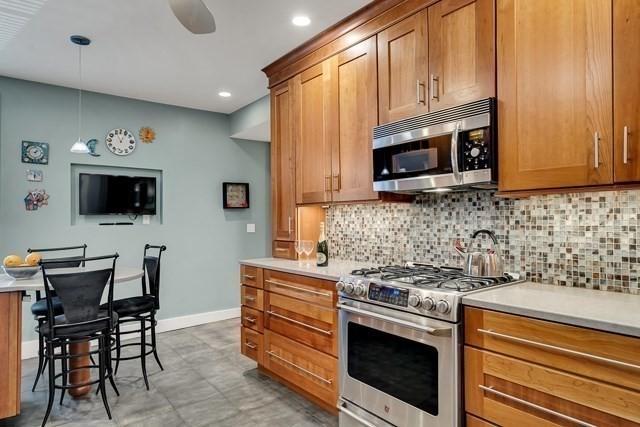 15 Thatcher St Unit F2-2, Brookline, MA 02446 - kitchen featuring stainless steel appliances, tasteful backsplash, brown cabinetry, light countertops, and recessed lighting