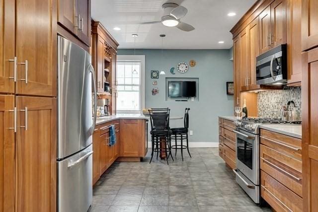 15 Thatcher St Unit F2-2, Brookline, MA 02446 - kitchen featuring appliances with stainless steel finishes, ceiling fan, backsplash, brown cabinets, and recessed lighting