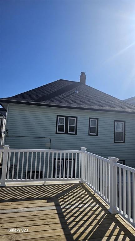 back of property with a shingled roof